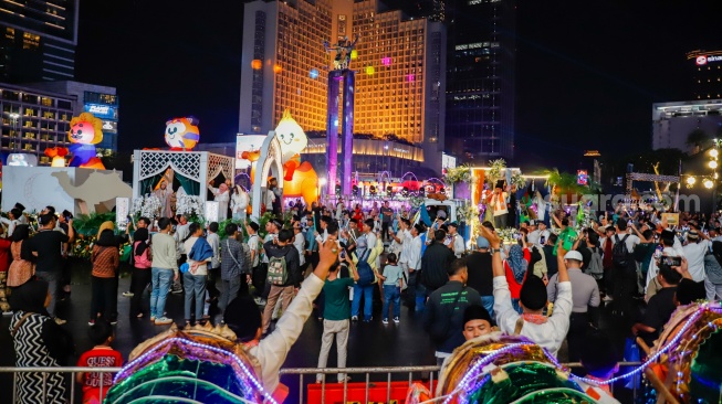 Sejumlah warga menyaksikan pawai obor dan fetival bedug dalam rangka menyambut Hari Raya Idul Fitri 1447 Hijriah di Bundaran HI, Jakarta, Jumat (20/3/2026). [Suara.com/Alfian Winanto]
 