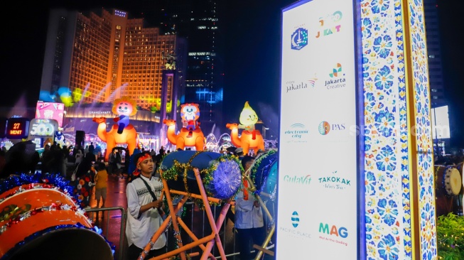 Sejumlah warga menyaksikan pawai obor dan fetival bedug dalam rangka menyambut Hari Raya Idul Fitri 1447 Hijriah di Bundaran HI, Jakarta, Jumat (20/3/2026). [Suara.com/Alfian Winanto]
 