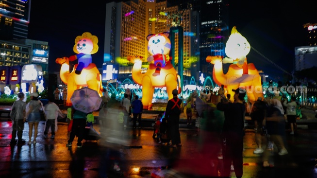 Sejumlah warga menyaksikan pawai obor dan fetival bedug dalam rangka menyambut Hari Raya Idul Fitri 1447 Hijriah di Bundaran HI, Jakarta, Jumat (20/3/2026). [Suara.com/Alfian Winanto]
 