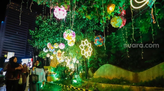 Sejumlah warga menyaksikan pawai obor dan fetival bedug dalam rangka menyambut Hari Raya Idul Fitri 1447 Hijriah di Bundaran HI, Jakarta, Jumat (20/3/2026). [Suara.com/Alfian Winanto]
 