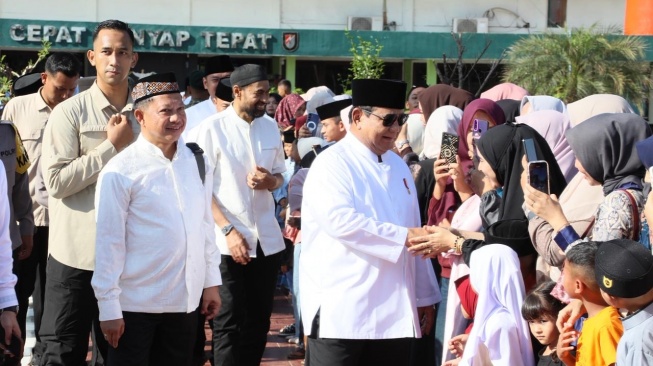 Presiden tengah membagikan bingkisan Lebaran berupa paket sembako dan perlengkapan ibadah secara simbolis kepada masyarakat Aceh Tamiang (Dok: Satgas PRR)
