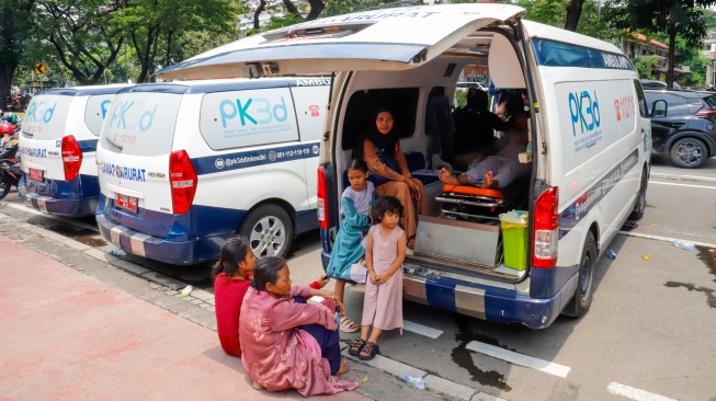 Warga yang tidak kuat beristirshat di ambulans saat mengantre dan menunggu masuk untuk Halal bihalal bersama Presiden di Istana Negara, Jakarta, Sabtu (21/3/2026). [Suara.com/Alfian Winanto]