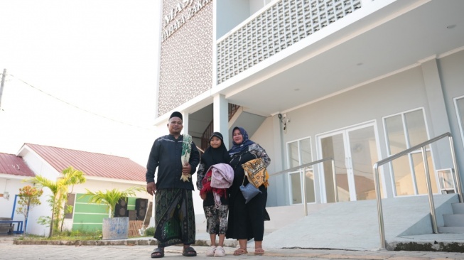 Warsana bersama istri dan anaknya di depan rumah baru mereka di Kampung Nelayan Sejahtera, Desa Eretan Kulon, Kabupaten Indramayu. (Dok: Kemensos)