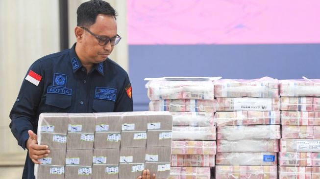 Petugas menata barang bukti yang ditunjukkan saat konferensi pers di Kantor Kejaksaan Tinggi Kalimantan Timur di Samarinda, Kaltim, Kamis (26/3/2026). [ANTARA FOTO/M Risyal Hidayat/bar]