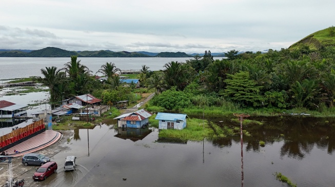 Mobil melintasi genangan air luapan Danau Sentani di Kalkhote, Asei Besar, Sentani Timur, Kabupaten Jayapura, Papua, Jumat (27/3/2026). [ANTARA FOTO/Gusti Tanati/sgd]