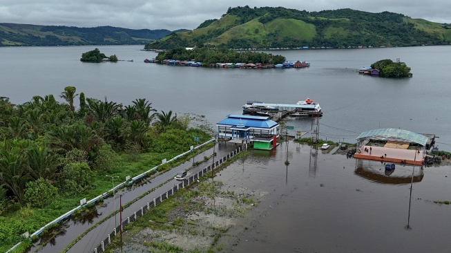 Mobil melintasi genangan air luapan Danau Sentani di Kalkhote, Asei Besar, Sentani Timur, Kabupaten Jayapura, Papua, Jumat (27/3/2026). [ANTARA FOTO/Gusti Tanati/sgd]
