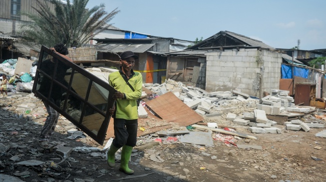 Petugas Suku Dinas Pertamanan dan Hutan Kota membantu warga membawa kayu jendela di Kamal, Kalideres, Jakarta, Selasa (31/3/2026). [ANTARA FOTO/Putra M. Akbar/tom]
