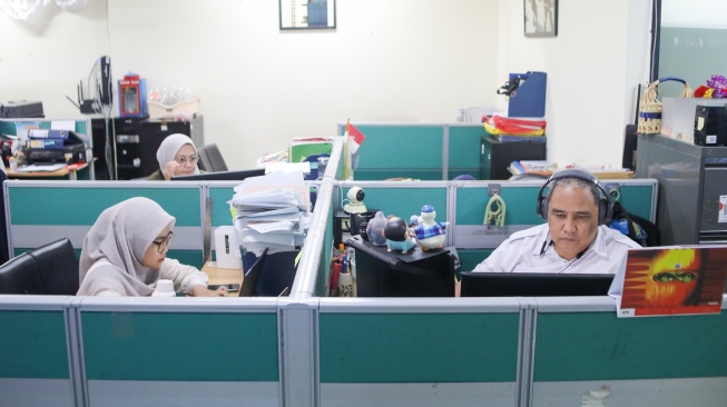 Aparatur Sipil Negara (ASN) menyelesaikan pekerjaan di Balai Kota DKI Jakarta, Rabu (1/4/2026). [Suara.com/Alfian Winanto]