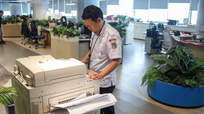 Aparatur Sipil Negara (ASN) menyelesaikan pekerjaan di Balai Kota DKI Jakarta, Rabu (1/4/2026). [Suara.com/Alfian Winanto]