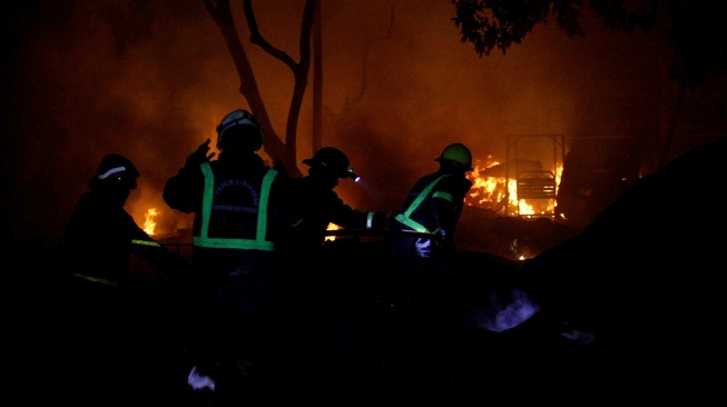 Petugas berusaha memadamkan api yang membakar rumah warga akibat kebakaran Stasiun Pengisian Bulk Elpiji (SPBE) Cimuning di Mustikajaya, Bekasi, Jawa Barat, Rabu (1/4/2026). [ANTARA FOTO/Darryl Ramadhan/rwa]
