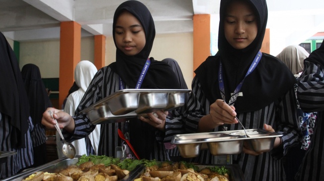 Siswa antre mengambil makanan secara prasmanan dalam uji coba pelaksanaan program Makan Bergizi Gratis (MBG) di MIN 2 Kota Malang, Jawa Timur, Kamis (2/4/2026). [ANTARA FOTO/Ari Bowo Sucipto/rwa]
