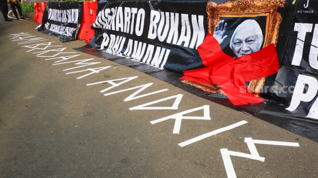 Tulisan dukungan untuk korban penyiraman air keras, Andrie Yunus saat Aksi Kamisan ke-902 di depan Istana Merdeka, Jakarta, Kamis (2/4/2026). [Suara.com/Alfian Winanto]