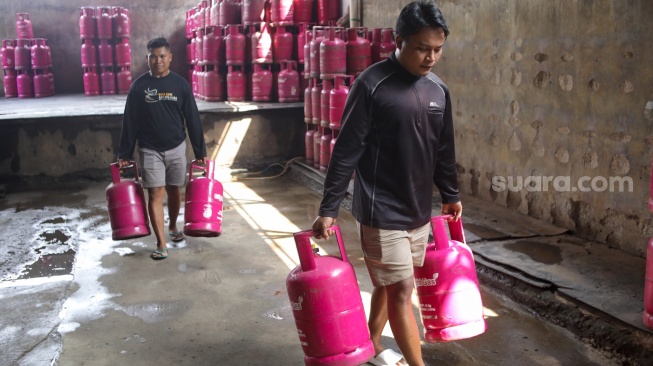 Petugas memindahkan tabung Liquefied Petroleum Gas (LPG) ukuran 12 kg di agen, kawasan Pasar Rebo, Jakarta, Senin (6/4/2026). [Suara.com/Alfian Winanto]
