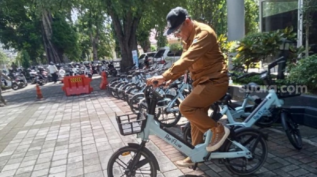 Kepala Dinas Sosial Kota Mataram saat sedang parkir sepeda [Suarabali.id/Buniamin]