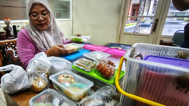 Yanti, pedagang keliling memiih mengurangi keuntungan agar tetap berjualan akibat naiknya harga plastik," Selasa (7/4/2026). [Suara.com/Putu]