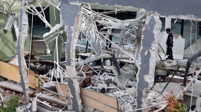 Pekerja merapikan material sisa bangunan rusak yang diduga akibat ledakan tabung gas di area olahraga Loxus Padel, Ciangsana, Gunungputri, Kabupaten Bogor, Jawa Barat, Kamis (9/4/2026). [ANTARA FOTO/Yulius Satria Wijaya/YU]