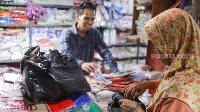 Pedagang melayani pembeli plastik di Pasar Minggu, Jakarta, Kamis (9/4/2026). [Suara.com/Alfian Winanto]
