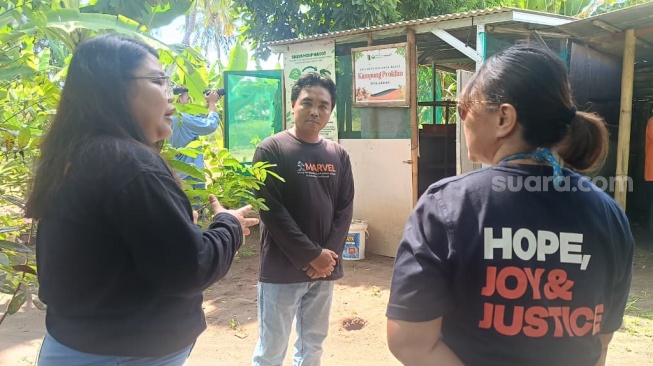 Dedi, peternak ayam kampung dan maggot di Lombok Timur, NTB saat berbincang dengan perwakilan dari WVI. (Suara.com/Dwi Bowo Raharjo)