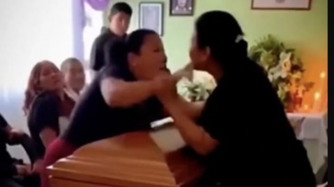Suasana duka di sebuah rumah duka di Veracruz, Meksiko, berubah menjadi kekacauan setelah dua wanita terlibat perkelahian di depan peti mati. [The Sun]