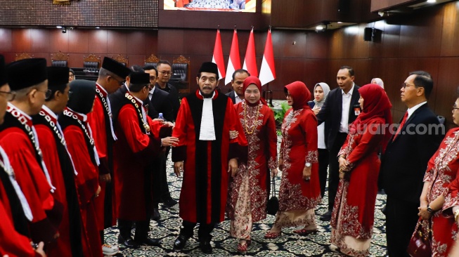 Hakim Konstitusi Anwar Usman berjalan ke depan gedung saat acara Wisuda Purnabakti dan Penyambutan Hakim di Gedung Mahkamah Konstitusi, Jakarta, Senin (13/4/2026). [Suara.com/Alfian Winanto]