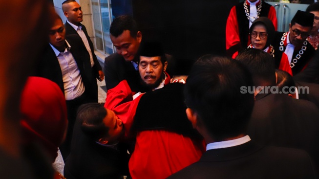 Hakim Konstitusi Anwar Usman (tengah) pingsan saat acara Wisuda Purnabakti dan Penyambutan Hakim di Gedung Mahkamah Konstitusi, Jakarta, Senin (13/4/2026). [Suara.com/Alfian Winanto]