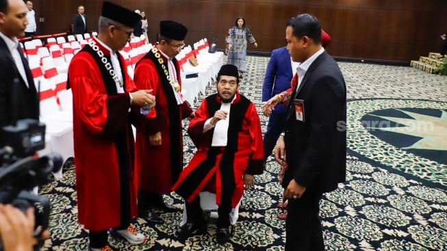 Hakim Konstitusi Anwar Usman duduk beristirahat saat acara Wisuda Purnabakti dan Penyambutan Hakim di Gedung Mahkamah Konstitusi, Jakarta, Senin (13/4/2026). [Suara.com/Alfian Winanto]