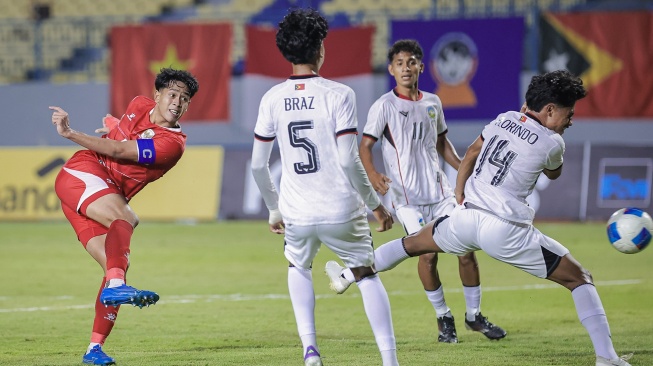 Pesepak bola Timnas Indonesia Putu Ekayana (kiri) menendang bola dan berusaha dihalau pesepak bola Timor Leste Florindo De Araujo (kanan) pada pertandingan penyisihan grup A ASEAN U-17 Boys Championship atau AFF U-17 di Stadion Gelora Joko Samudro, Gresik, Jawa Timur, Senin (13/4/2026). [ANTARA FOTO/Rizal Hanafi/sgd]