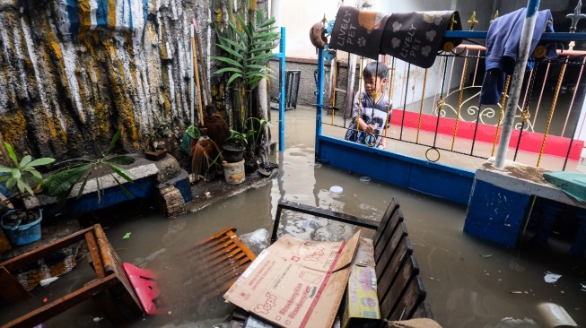 Seorang anak menutup pintu gerbang rumahnya yang terendam banjir di Kampung Gambiran, Kabupaten Sukoharjo, Jawa Tengah, Rabu (15/4/2026). [ANTARAFOTO/Maulana Surya/YU]