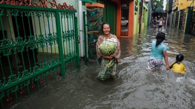Warga melintasi banjir di Kampung Sanggrahan, Kabupaten Sukoharjo, Jawa Tengah, Rabu (15/4/2026). [ANTARAFOTO/Maulana Surya/YU]