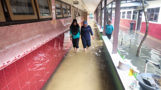 Sejumlah guru melintas di depan ruang kelas yang terdampak banjir di SD Negeri Sanggrahan 01, Kabupaten Sukoharjo, Jawa Tengah, Rabu (15/4/2026). [ANTARAFOTO/Maulana Surya/YU]