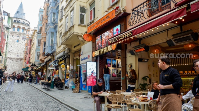 Wisatawan memadati kawasan Galata dengan latar belakang Menara Galata di Kota Istanbul, Turki, Rabu (15/4/2026). [Suara.com/Iramdani]
