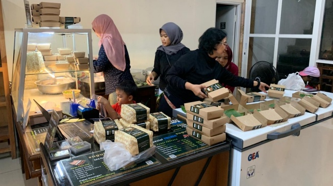 Proses penyajian Jadah Tempe Mbah Carik di Jalan Kaliurang, Sleman. (Suara.com/Irwan Febri)
