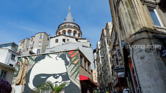 Wisatawan memadati kawasan Galata dengan latar belakang Menara Galata di Kota Istanbul, Turki, Rabu (15/4/2026). [Suara.com/Iramdani]
