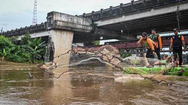 Petugas Unit Penanganan Sampah (UPS) Badan Air Dinas Lingkungan Hidup DKI Jakarta menggunakan jaring untuk menangkap ikan sapu-sapu saat operasi pembersihan di Sungai Ciliwung, Cililitan, Jakarta, Jumat (17/4/2026). ANTARA FOTO/Sulthony Hasanuddin/tom]
