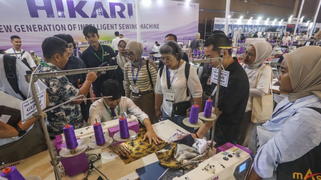 Petugas memeragakan cara penggunaan mesin jahit berteknologi AI dalam pameran Indo Intertex–Inatex 2026 di JIExpo Kemayoran, Jakarta, Kamis (16/4/2026). [Suara.com/Alfian Winanto]