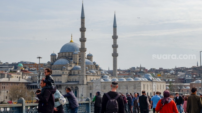 Wisatawan memadati Karaköy Street dengan latar belakang masjid bersejarah di Kota Istanbul, Turki, Rabu (15/4/2026). [Suara.com/Iramdani]