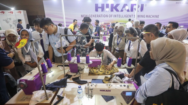 Petugas memeragakan cara penggunaan mesin jahit berteknologi AI dalam pameran Indo Intertex–Inatex 2026 di JIExpo Kemayoran, Jakarta, Kamis (16/4/2026). [Suara.com/Alfian Winanto]