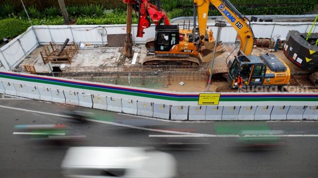Kendaraan melintas di jalan yang menyempit dampak adanya pengerjaan proyek revitalisasi di Jalan M.H. Thamrin, Jakarta, Senin (20/4/2026). [Suara.com/Alfian Winanto]