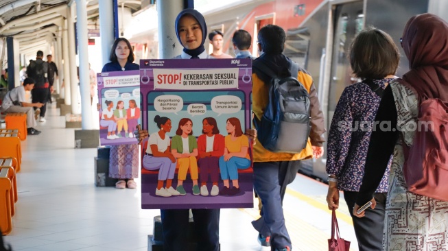 Petugas membawa poster kampanye anti kekerasan seksual di Stasiun Sudirman, Jakarta, Selasa (21/4/2026). [Suara.com/Alfian Winanto]
