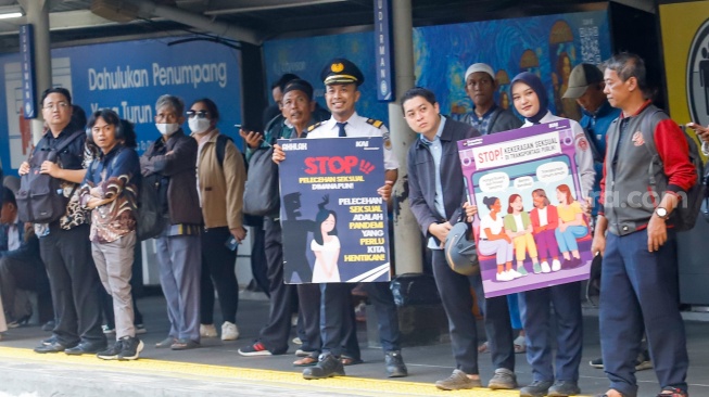 Petugas membawa poster kampanye anti kekerasan seksual di Stasiun Sudirman, Jakarta, Selasa (21/4/2026). [Suara.com/Alfian Winanto]
