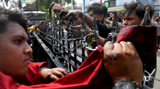 Masa aksi berusaha melepas kawat berduri saat unjuk rasa di depan kantor Gubernur Kalimantan Timur, Samarinda, Kalimantan Timur, Selasa (21/4/2026). [ANTARA FOTO/Angga Palguna/bar]