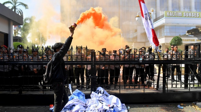Masa aksi menyalakan flare saat unjuk rasa di depan kantor Gubernur Kalimantan Timur, Samarinda, Kalimantan Timur, Selasa (21/4/2026). [ANTARA FOTO/Angga Palguna/bar]