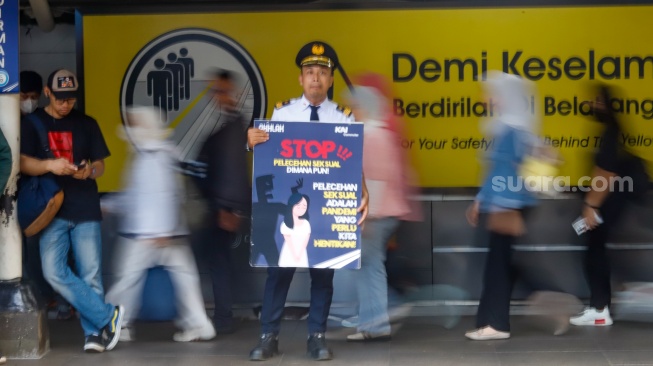 Petugas membawa poster kampanye anti kekerasan seksual di Stasiun Sudirman, Jakarta, Selasa (21/4/2026). [Suara.com/Alfian Winanto]
