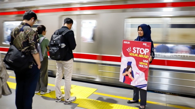 Petugas membawa poster kampanye anti kekerasan seksual di Stasiun Sudirman, Jakarta, Selasa (21/4/2026). [Suara.com/Alfian Winanto]

