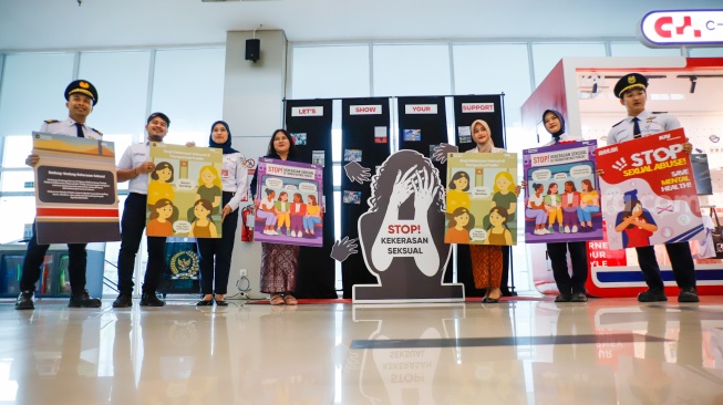 Petugas membawa poster kampanye anti kekerasan seksual di Stasiun BNI City, Jakarta, Selasa (21/4/2026). [Suara.com/Alfian Winanto]
