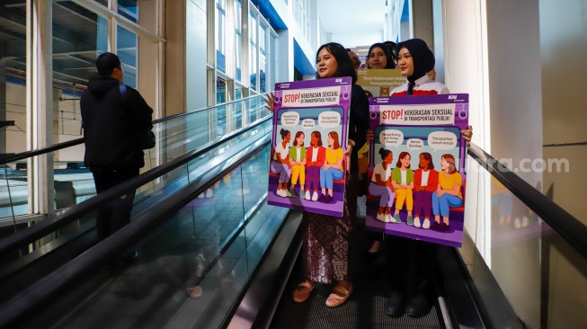 Petugas membawa poster kampanye anti kekerasan seksual di Stasiun BNI City, Jakarta, Selasa (21/4/2026). [Suara.com/Alfian Winanto]
