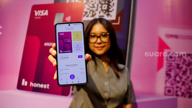 Model menunjukkan aplikasi Honest Card saat peluncuran fitur pembayaran QRIS Merchant Presented Mode (MPM) di Jakarta, Selasa (21/4/2026). [Suara.com/Alfian Winanto]
