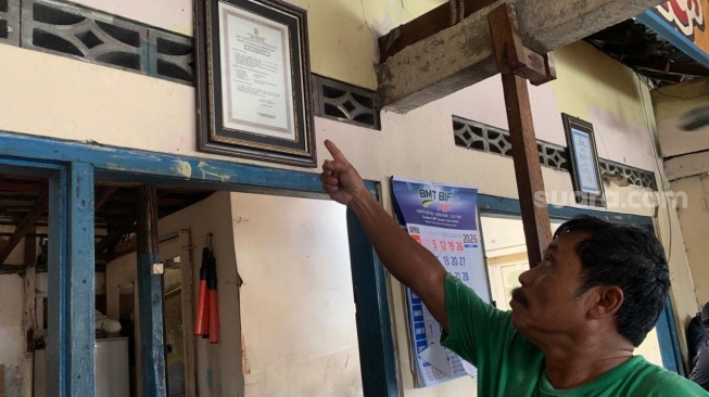 Pemilik Mi Ayam TPMC, Edi Rosadi, menunjukkan serfitikat BPOM di warungnya. (Suara.com/Irwan Febri)