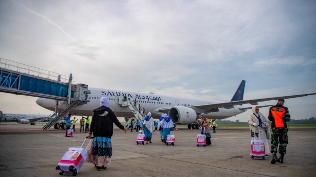Jamaah calon haji kelompok terbang (kloter) pertama embarkasi Palembang (PLM 01) berjalan menuju pesawat yang akan membawa mereka menuju tanah suci, di Bandara Internasional Sultan Mahmud Baddarudin (SMB) II Palembang, Sumatera Selatan, Rabu (22/4/2026). [ANTARA FOTO/Nova Wahyudi/kye]