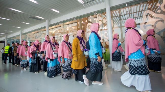 Jamaah calon haji berjalan menuju pesawat saat pemberangkatan di BIJB Kertajati, Majalengka, Jawa Barat, Rabu (22/4/2026). [ANTARA FOTO/Dedi Suwidiantoro/kye]